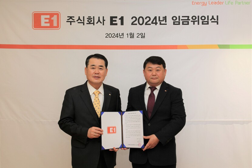 E1 구자용 회장(왼쪽)과 박승규 노조위원장이 2024년도 임금에 관한 위임장을 들고 기념 촬영을 하고 있다.