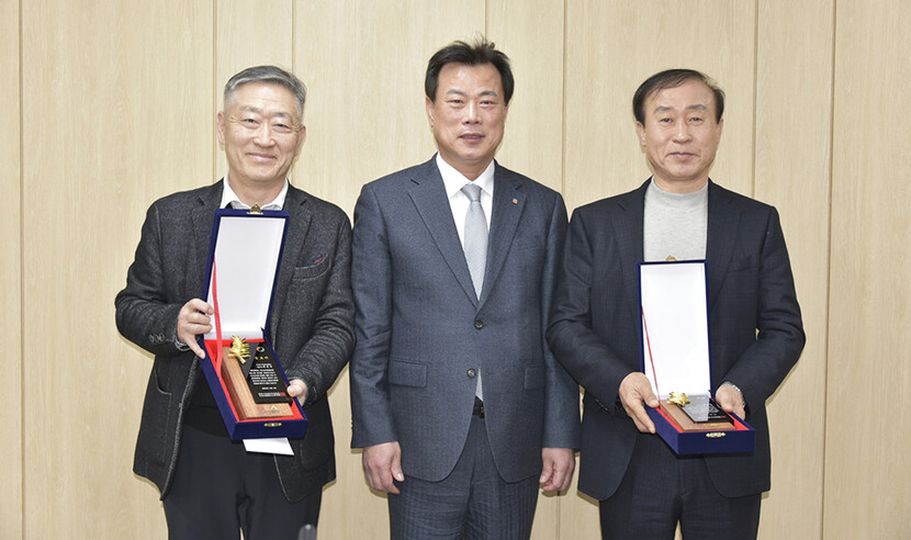 공로패를 받은 최종각 대표(왼쪽)와 김종선 대표(오른쪽)가 김영태 회장과 사진을 찍고 있다.