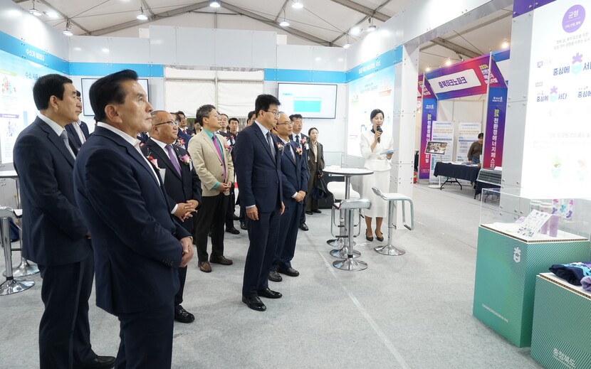 참석자들이 전시회 부스에서 친환경 에너지에 대한 설명을 듣고 있다.